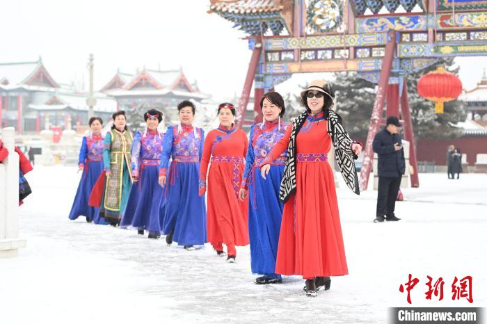 2月13日，老年人在呼和浩特市大召?gòu)V場(chǎng)拍照“打卡”。　劉文華 攝