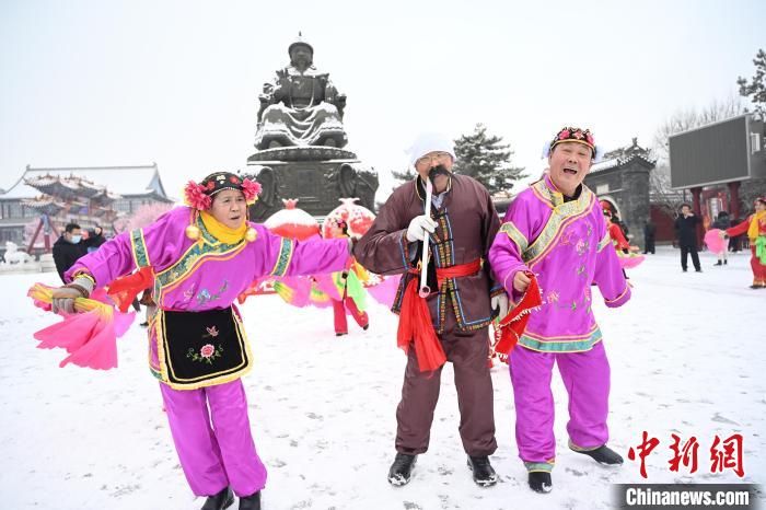 2月13日，秧歌隊(duì)在呼和浩特市大召?gòu)V場(chǎng)雪中起舞?！⑽娜A 攝