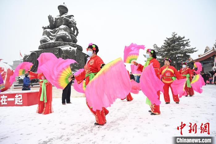 2月13日，秧歌隊(duì)在呼和浩特市大召?gòu)V場(chǎng)雪中起舞。　劉文華 攝