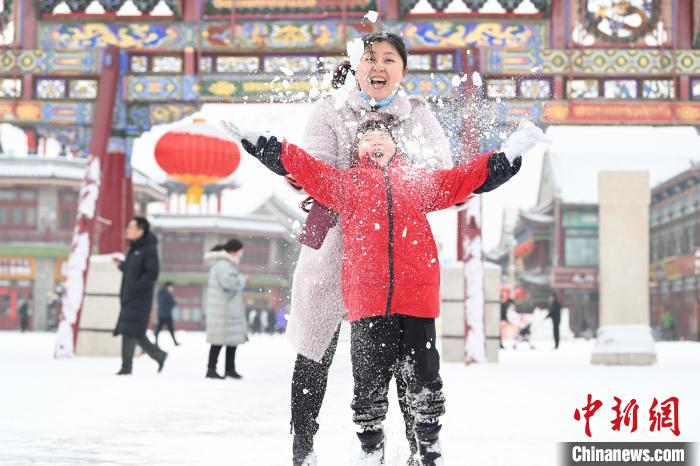 2月13日，家長(zhǎng)與小朋友在呼和浩特市大召?gòu)V場(chǎng)享雪趣。　劉文華 攝