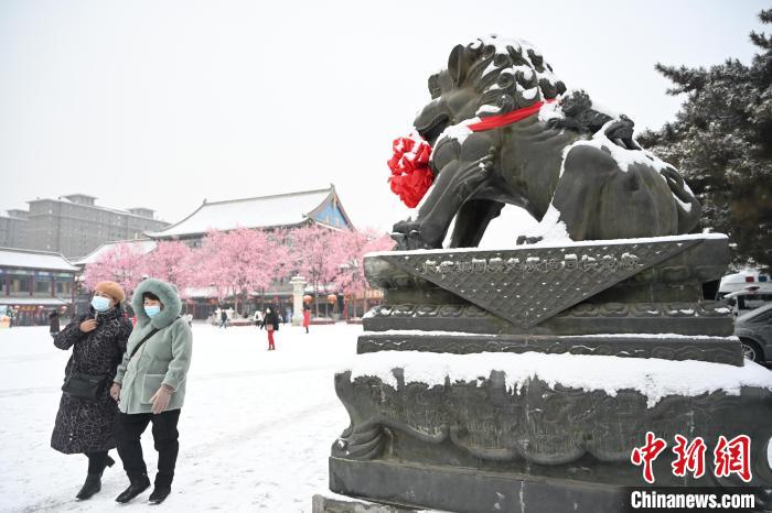 2月13日，民眾在呼和浩特市大召?gòu)V場(chǎng)雪中漫步?！⑽娜A 攝