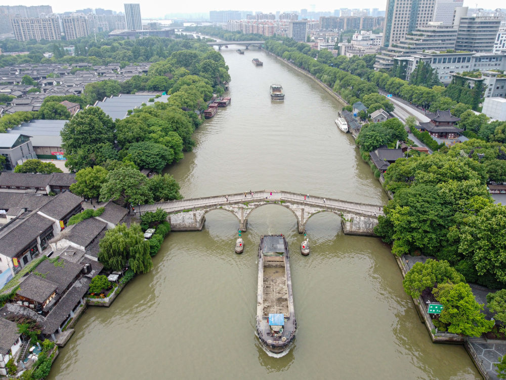 5月27日，一艘貨船駛過京杭大運河南端標志建筑杭州拱宸橋。(無人機照片)新華社記者江漢 攝