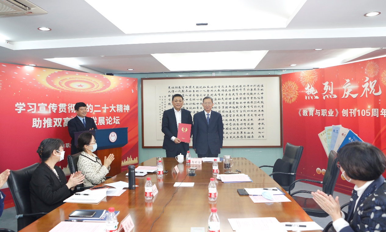 郝明金為《教育與職業(yè)》雜志編委代表陳曉明頒發(fā)聘書。中華職教社供圖