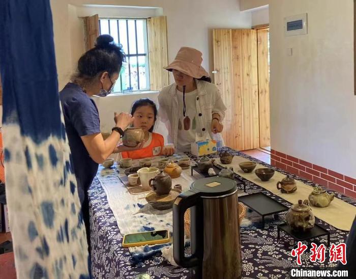 圖為：游客正在咨詢臺灣柴燒作品?！∪~秋云 攝