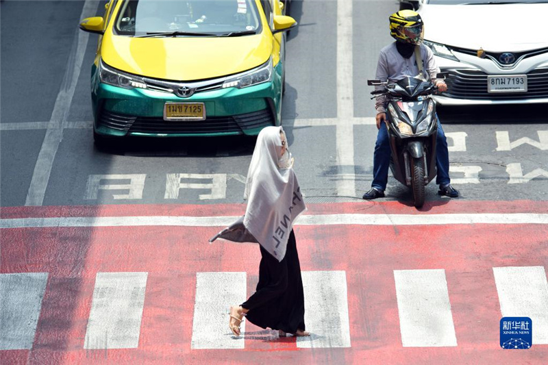 5月17日，行人在泰國曼谷街頭用圍巾遮陽。新華社發(fā)（拉亨攝）
