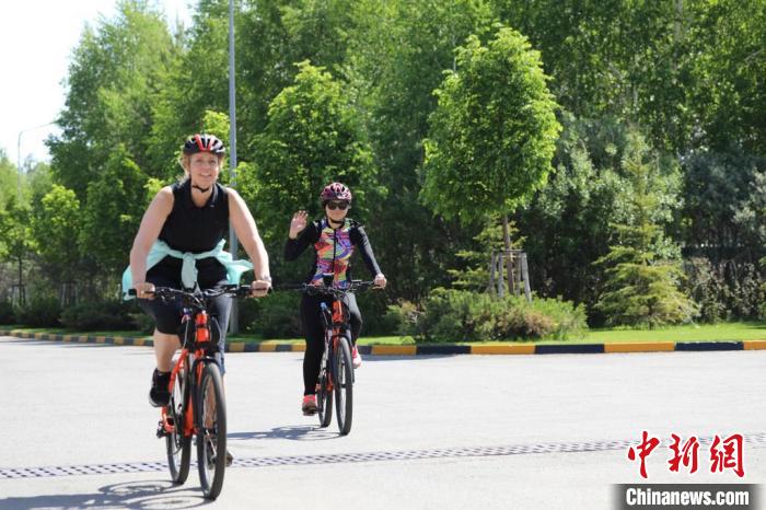 亞信副秘書長遲方(右一)與聯(lián)合國駐哈協(xié)調員在騎行活動中。　亞信秘書處供圖