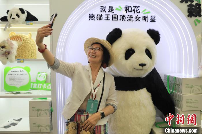 美國華視總裁楊蓮花與大熊貓文創(chuàng)產品合影?！⊥趵?攝
