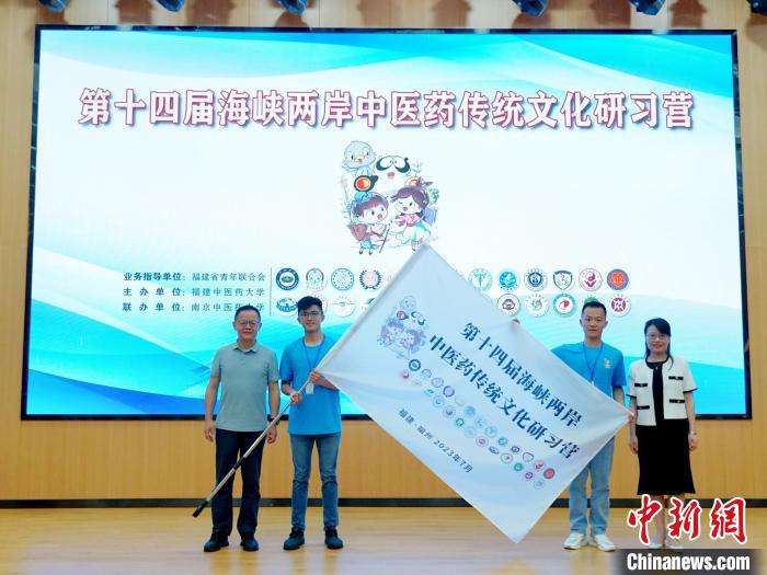 共青團(tuán)福建省委副書記吳雪(右一)、福建中醫(yī)藥大學(xué)黨委副書記林羽(左一)為兩岸學(xué)生代表頒授營(yíng)旗?！≡S燁婷 攝
