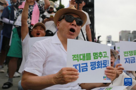 7月22日，在韓國首爾，人們手舉標語參與反戰(zhàn)游行。新華社發(fā)（楊暢 攝）