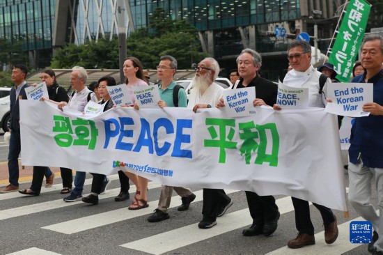 7月22日，在韓國首爾，人們手舉標語參與反戰(zhàn)游行。新華社發(fā)（楊暢 攝）