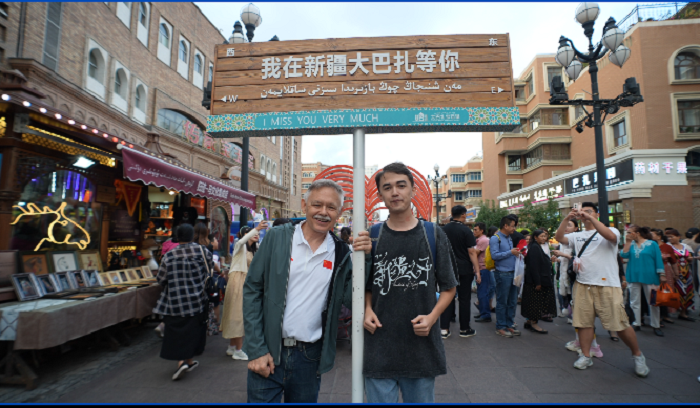潘維廉和維吾爾族青年伊木蘭“打卡”大巴扎。主辦方供圖
