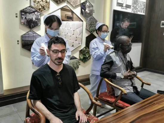 2023“一帶一路”媒體合作論壇聯(lián)合采訪團(tuán)團(tuán)員在九牛草展示館體驗(yàn)艾灸。（本報記者 黃超攝）