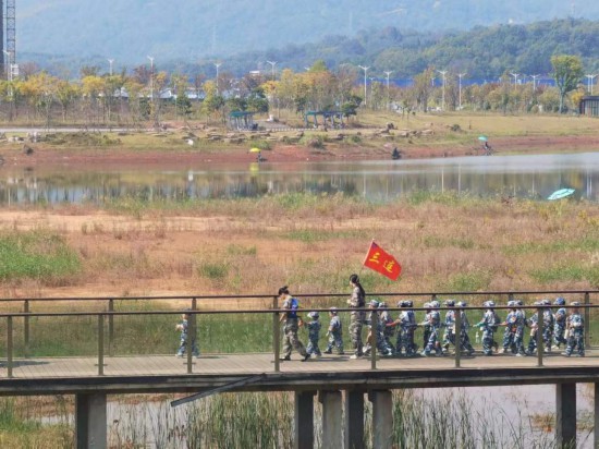 　　10月24日，秋游的幼兒園小朋友在老師帶領(lǐng)下走在清水塘公園里的木橋上。本報記者 常雯宜攝