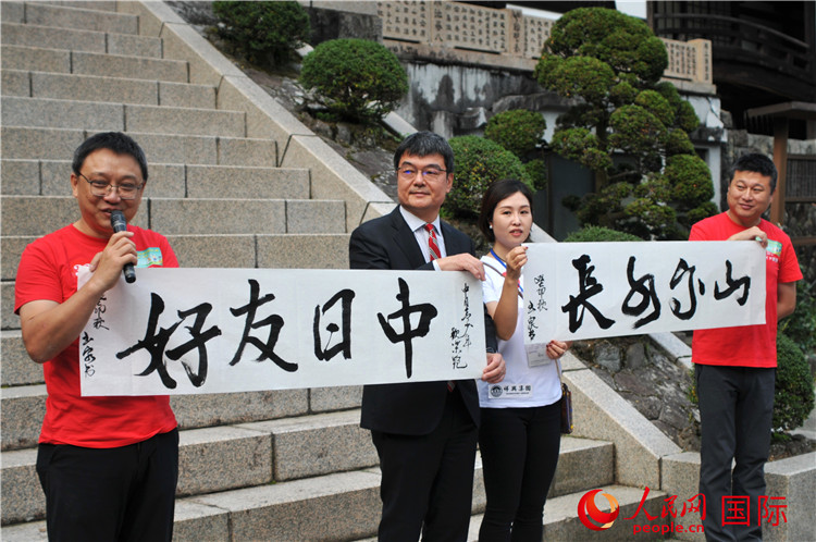 東京中國文化中心主任羅玉泉展示其為本次活動(dòng)書寫的題詞“中日友好，山高水長”。人民網(wǎng) 蔣曉辰攝