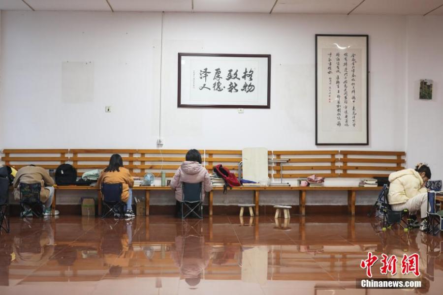 資料圖：幾位考研學(xué)生在南昌大學(xué)教學(xué)樓的公共空間復(fù)習(xí)備考。劉力鑫 攝