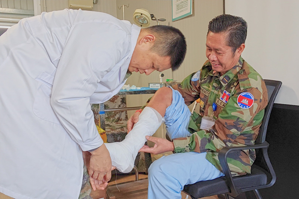 中國第22批赴黎維和醫(yī)療分隊軍醫(yī)為患者打石膏固定患肢。李清竹攝