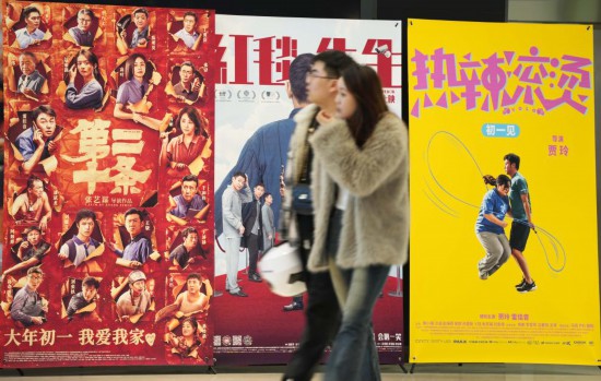 這是2月17日，在沈陽一家影院，觀眾從海報前經(jīng)過。新華社記者李鋼攝