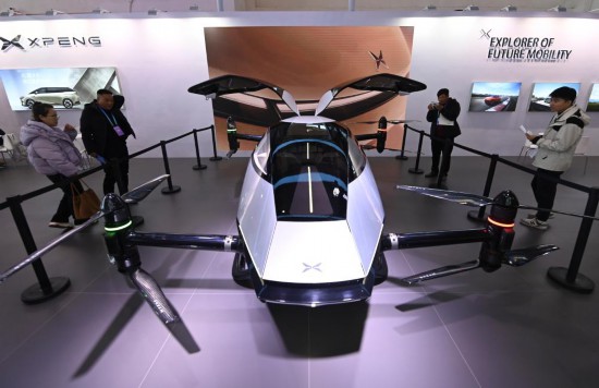 2023年12月1日，在鏈博會(huì)智能汽車鏈展區(qū)小鵬汽車展臺(tái)，參觀者觀看一臺(tái)智能飛行器。新華社記者蔡湘鑫攝