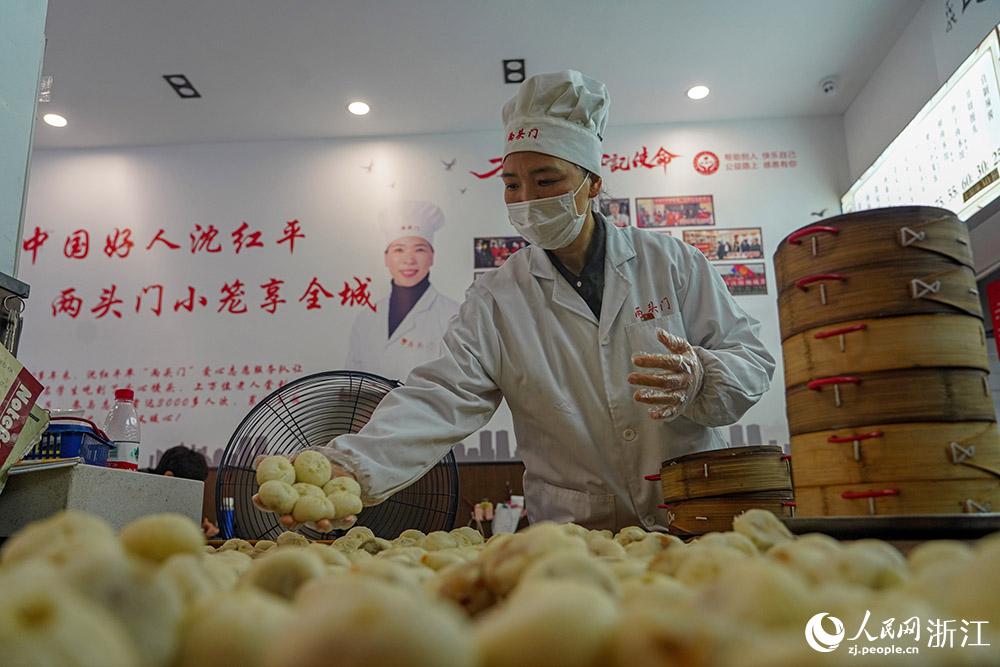 3月31日，在浙江省嵊州市甘霖鎮(zhèn)，嵊州小吃從業(yè)者沈紅平把蒸熟的小籠包晾涼，打包冷藏售賣。人民網(wǎng) 章勇濤攝