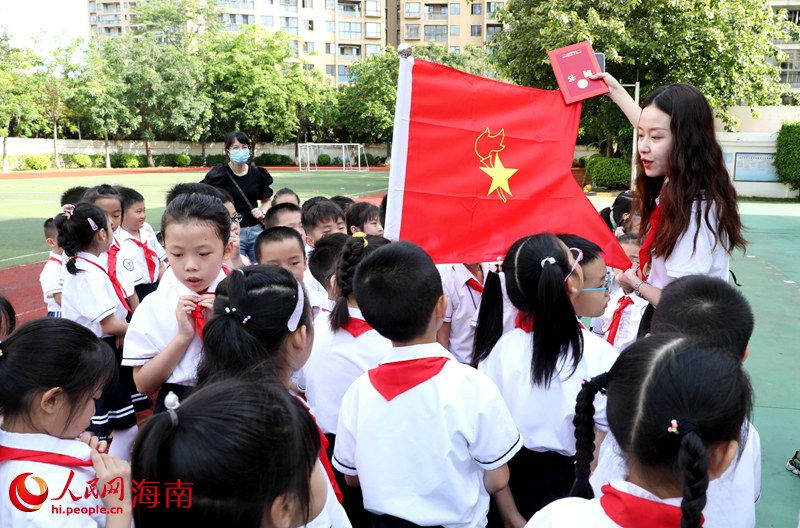 老師向少先隊(duì)員展示隊(duì)旗。人民網(wǎng) 符武平攝
