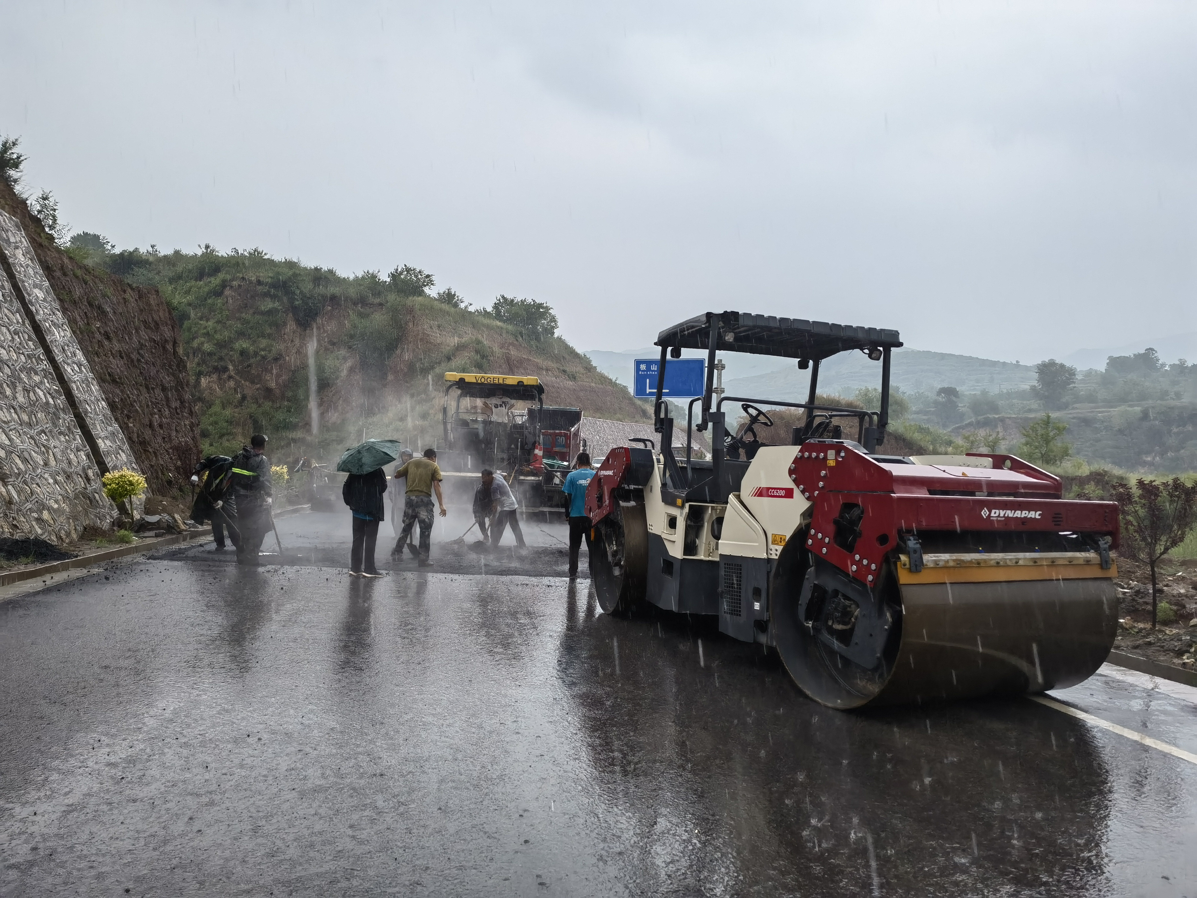路橋工人在大雨中搶修道路。李華英 攝