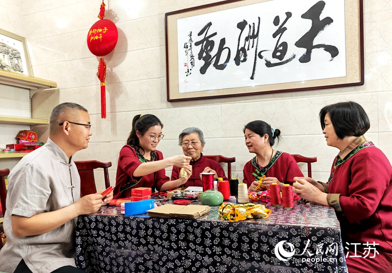 王秀英老人指導(dǎo)孫女制作香包。人民網(wǎng) 閆峰攝