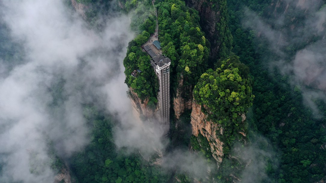 位于張家界武陵源景區(qū)的百龍?zhí)焯蓁偳对谠旗F繚繞的峰林間，雄偉壯觀。吳勇兵攝