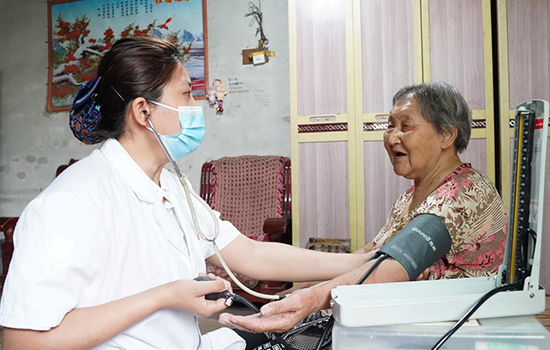護(hù)理團(tuán)隊(duì)醫(yī)生為老人測量血壓。 陳佳兵攝