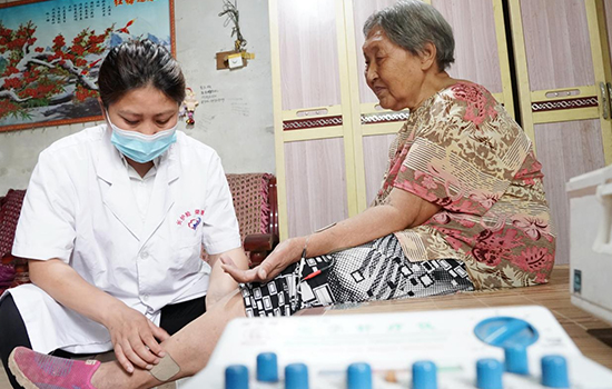 護(hù)理團(tuán)隊(duì)醫(yī)生為老人進(jìn)行低頻功能康復(fù)。陳佳兵攝