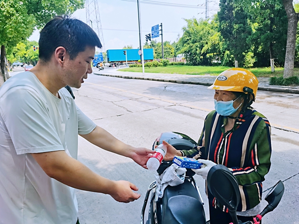 何超為過路的老人送上礦泉水和冷飲。人民網(wǎng)記者 王繼亮攝
