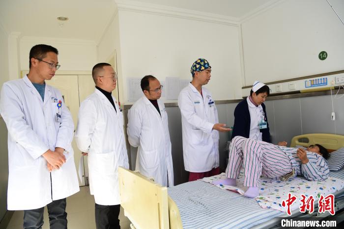 圖為何蔚副主任醫(yī)師(站右二)及團隊術后指導患者進行腰背肌鍛煉?！∝暩聛硭?攝