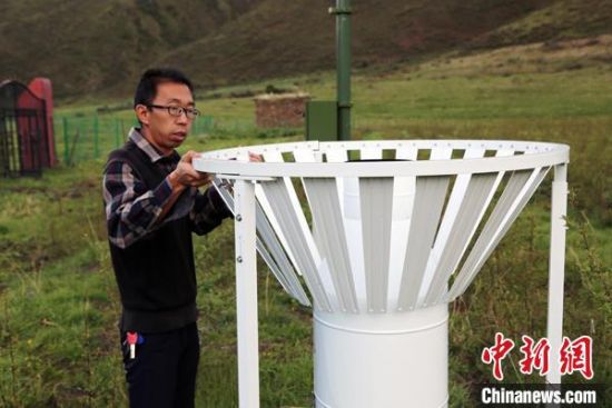圖為班瑪縣氣象局工作人員在維護(hù)藏雪茶基地氣候站。青海省氣象局供圖