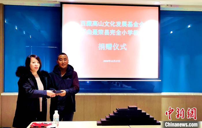 圖為西藏高山文化發(fā)展基金會理事長溫麗向聶榮縣完全小學負責人捐助儀器。　于賓 攝