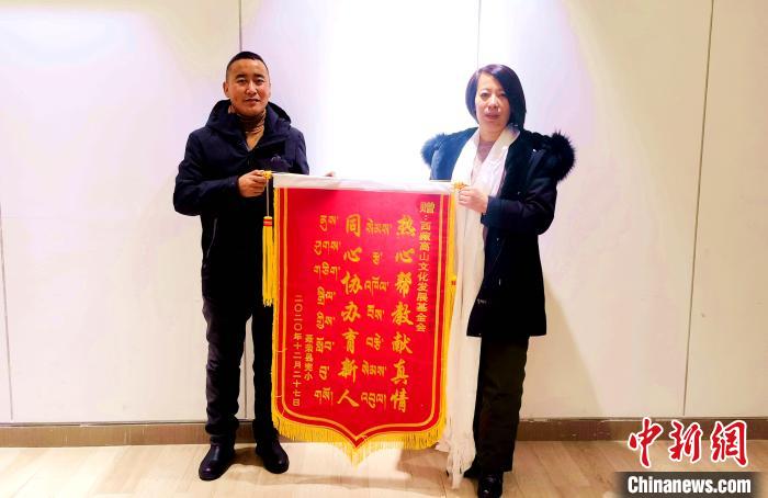 圖為聶榮縣完全小學向西藏高山文化發(fā)展基金會贈送錦旗?！∮谫e 攝
