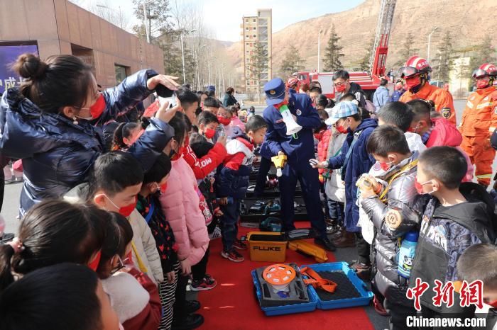圖為小朋友們聽(tīng)消防員講解消防器材?！铨埥?攝