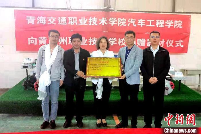 圖為李富香(中)代表學(xué)校為州縣技校捐贈(zèng)器材。(資料圖) 青海省教育廳供圖