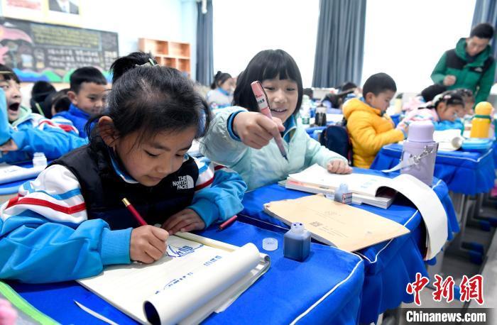 3月14日，西藏拉薩市第一小學一年級六班學生白瑪朗珍(圖左)在藏語文課上書寫藏文?！±盍?攝