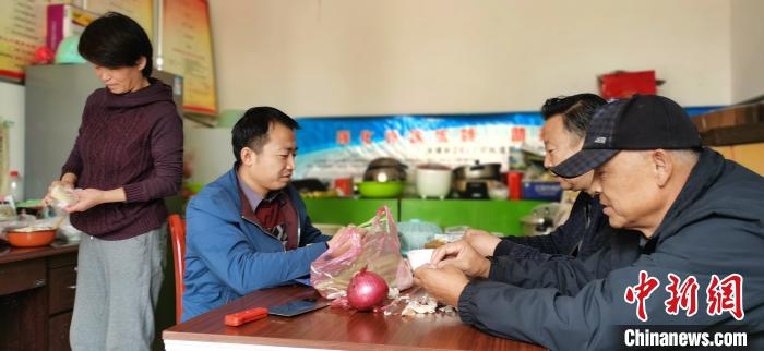圖為扶貧路上“臨時(shí)一家人”準(zhǔn)備午餐。　魏建軍 攝