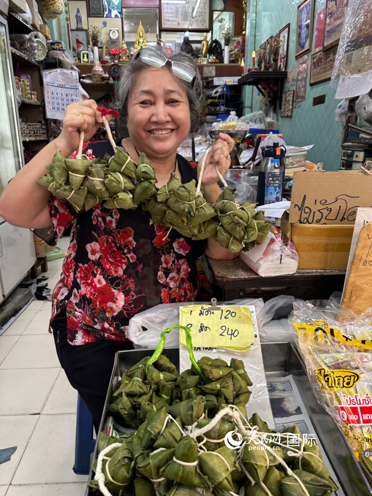 商家向顧客介紹“吉掌”（粽子的一種，一串一串，個頭較小）。人民網(wǎng)記者 簡承淵攝