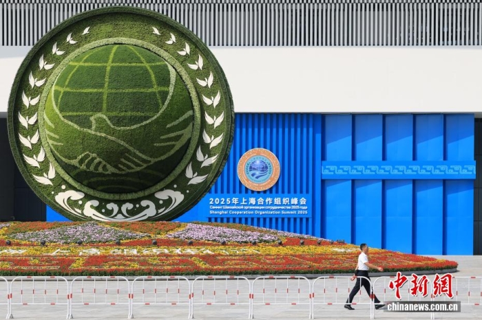 8月31日，天津，一名工作人員從2025年上海合作組織峰會主會場外的景觀花壇旁經(jīng)過。當(dāng)日，2025年上海合作組織峰會在天津舉行。<a target='_blank' href='/'><p  align=