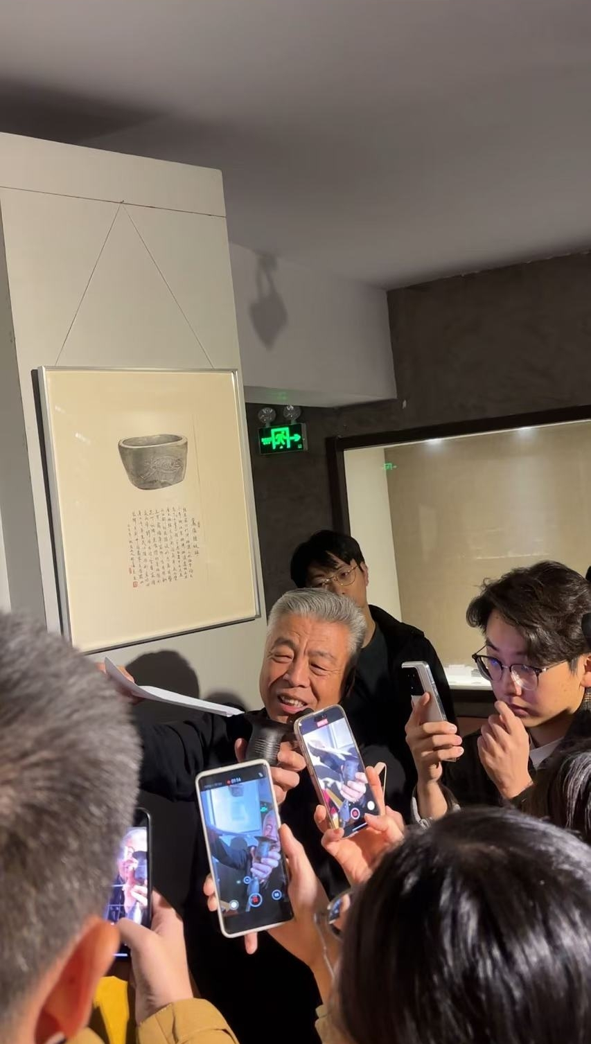 黑陶邢文化博物館館長邢葆東展示兩張相疊的A4紙，向記者解釋此為杯口的厚度。