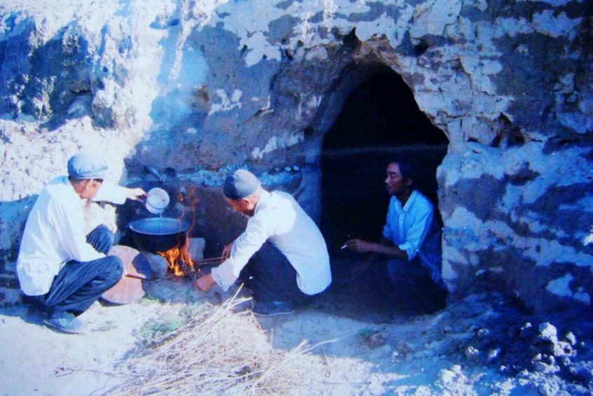 1983年，“六老漢”一代治沙人在“地窩子”生活做飯。新華社發(fā)（八步沙林場(chǎng)供圖）