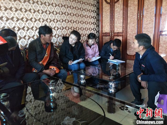 圖為調(diào)查組工作人員正在入戶調(diào)查?！∑钤鲚?攝