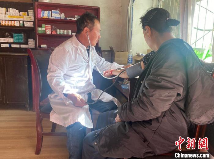 索木滾(左)為村民看病?！∪捞量h委宣傳部供圖