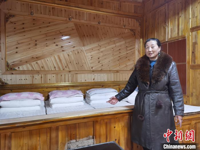 圖為德吉村村民鬧尖措介紹自家農(nóng)家樂?！∑钤鲚?攝