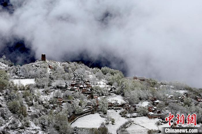 雪后的藏寨和碉樓構成美麗的雪景?！〗党鯘衫?攝