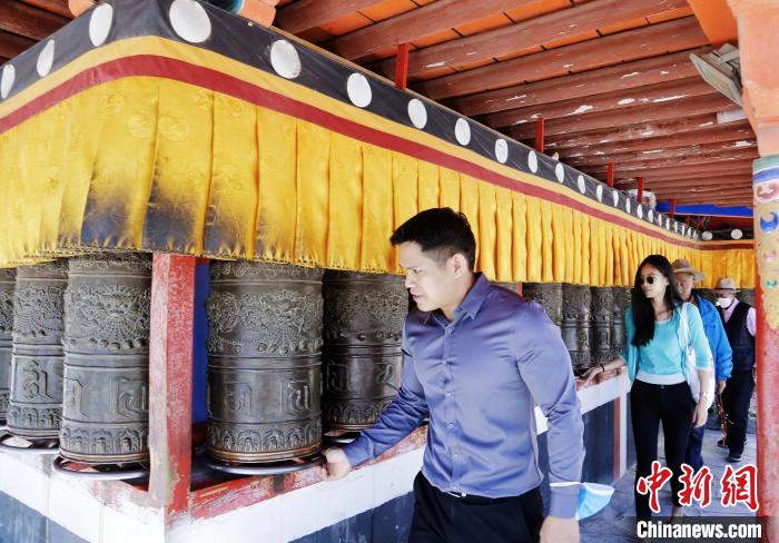 圖為外籍嘉賓體驗藏族傳統(tǒng)轉經筒?！●R銘言 攝