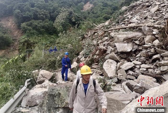 電力搶險(xiǎn)人員徒步通過(guò)垮塌路段?！∷拇娏﹫D