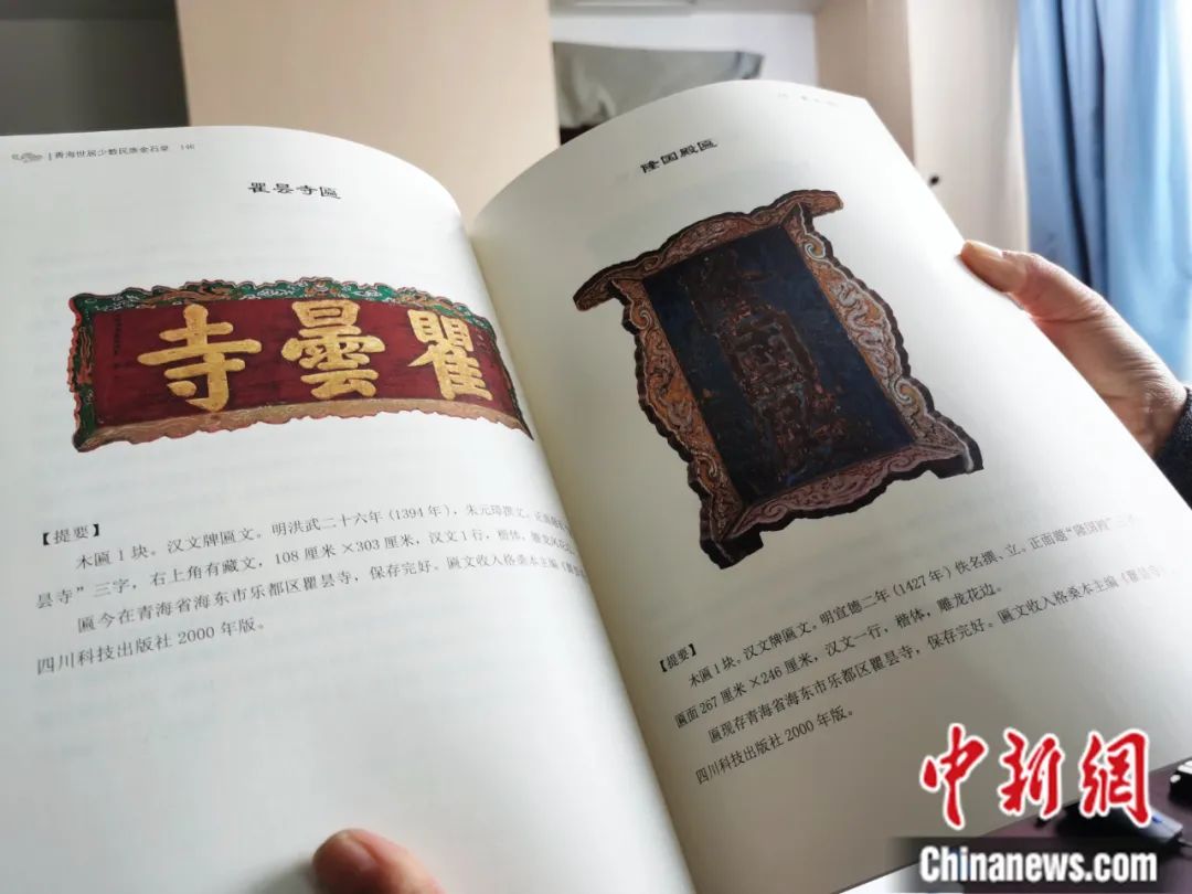 古籍保護(hù)人員展示介紹明代朱元璋撰寫的青海瞿曇寺匾(左)的出版書籍。張?zhí)砀?攝
