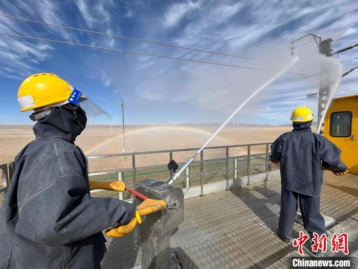 圖為水炮手操作高壓水槍對(duì)絕緣子進(jìn)行清洗。　高啟宏 攝